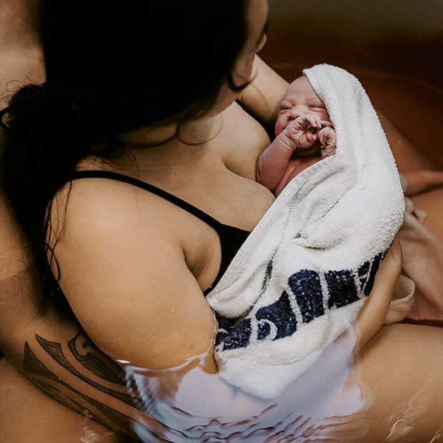 Newborn baby immediately after birth in water