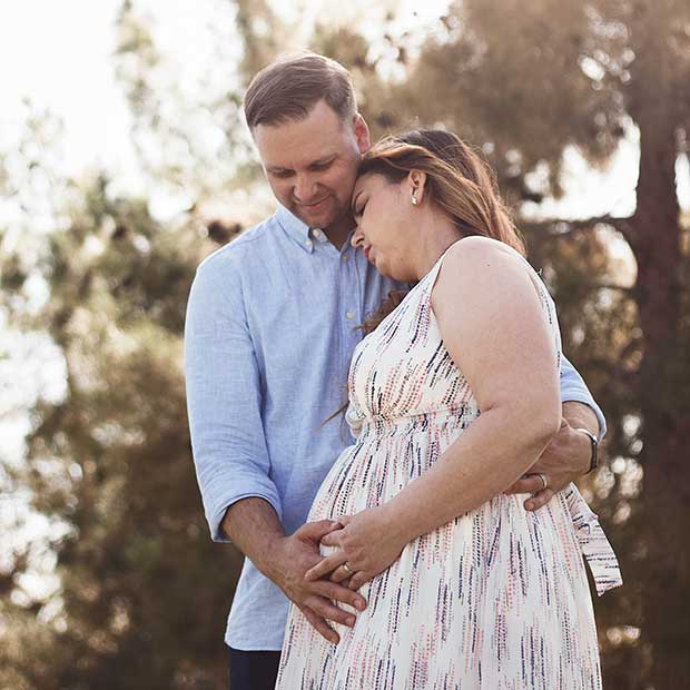 Partner embraces pregnant woman