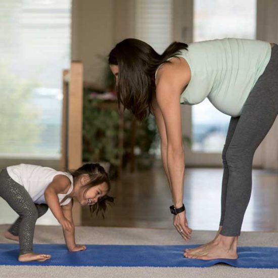 Pregnant mum doing yoga exercise with daughter