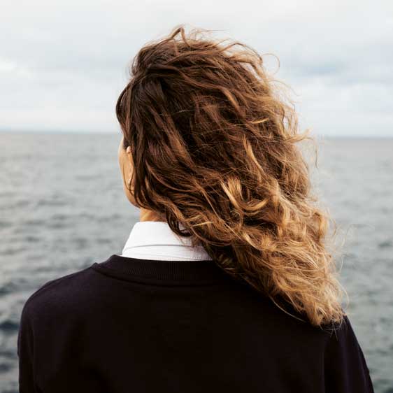 Grieving woman looks out to ocean