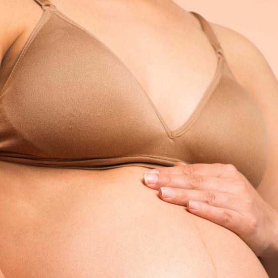 Pregnant woman wears nursing bra
