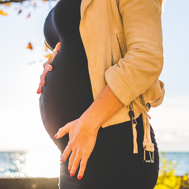 Woman shows off pregnant belly in sunshine