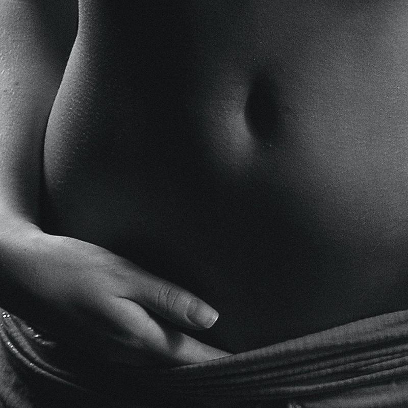 Pregnant woman touches belly in early pregnancy