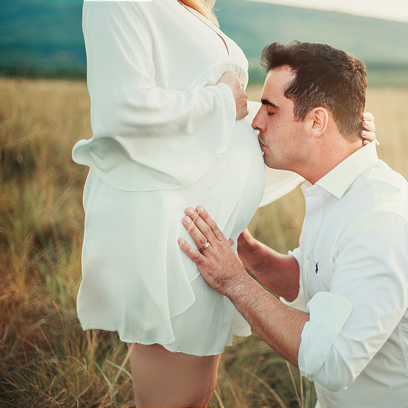 Husband kisses wife's pregnant belly