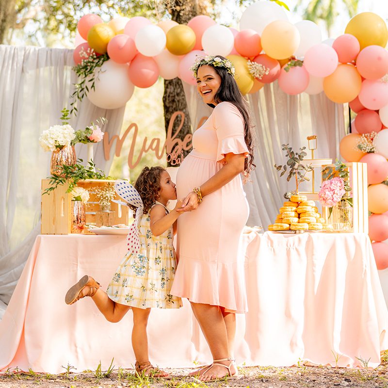 Child kisses mum's pregnant belly at baby shower