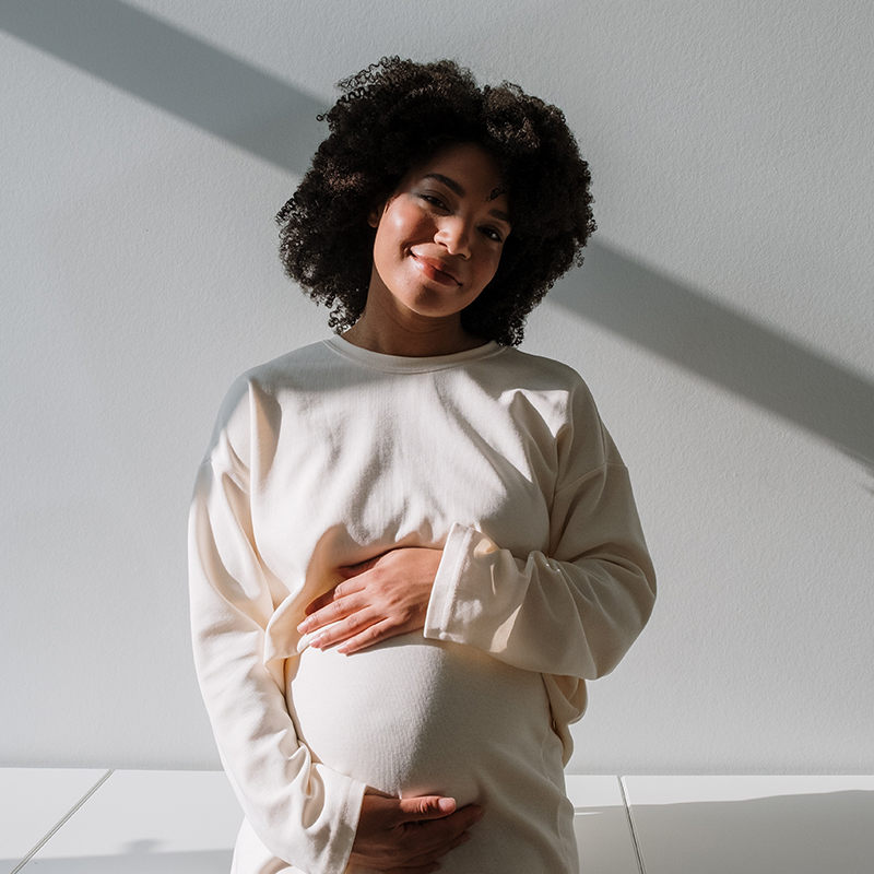 Pregnant mum holds her belly with both hands