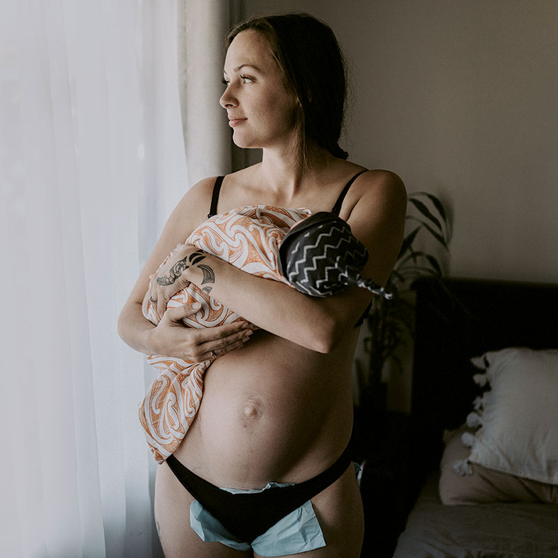 Postpartum mother holds newborn baby at home