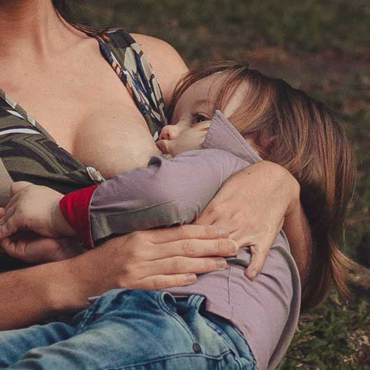 Toddler breastfeeding from mum