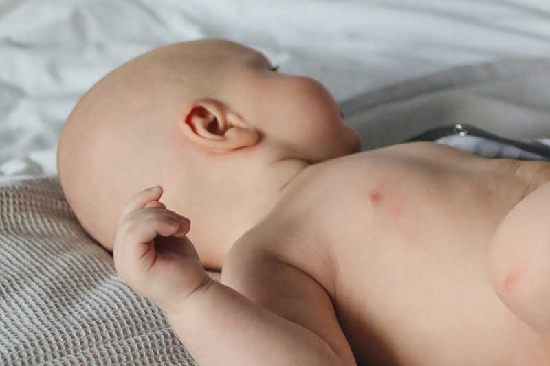 Infant baby with ear to camera