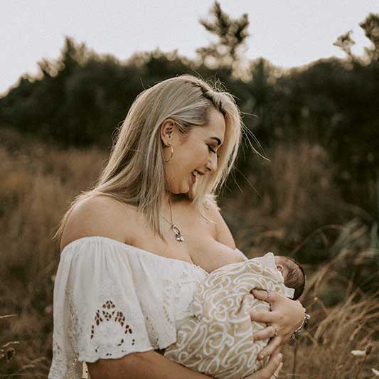 Mum breastfeeds her newborn baby in New Zealand