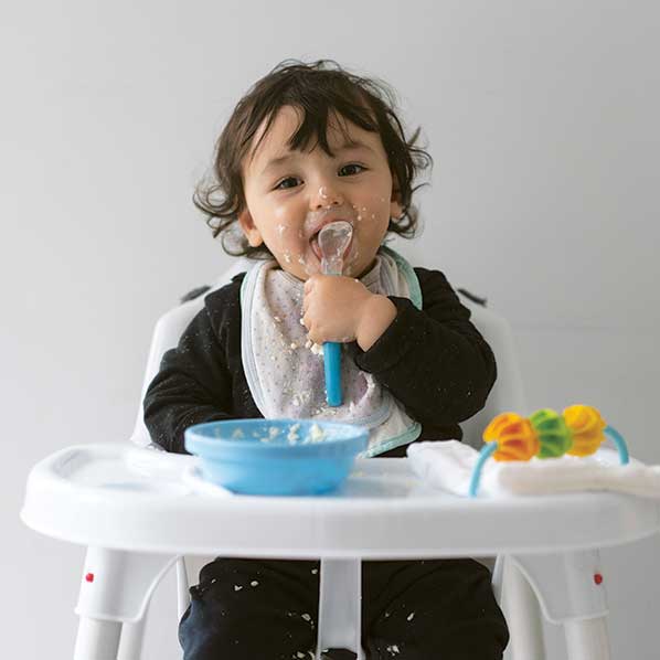 Healthy toddler eating a bowl of porridge
