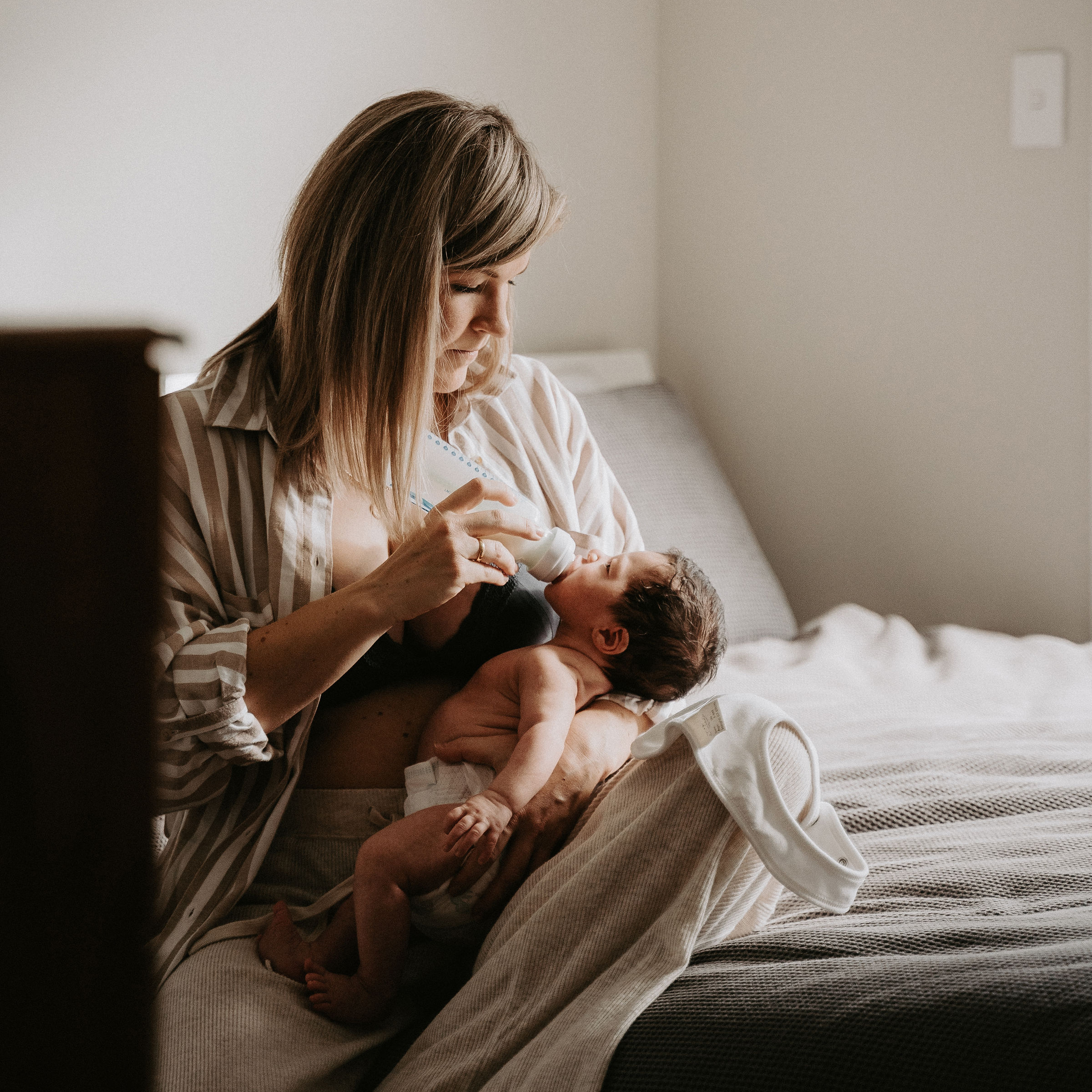 Māmā feeding baby with a bottle