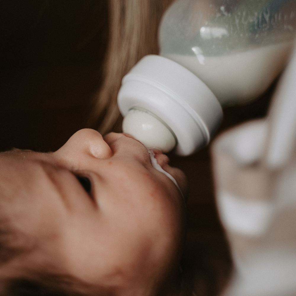 Baby drinks milk from bottle