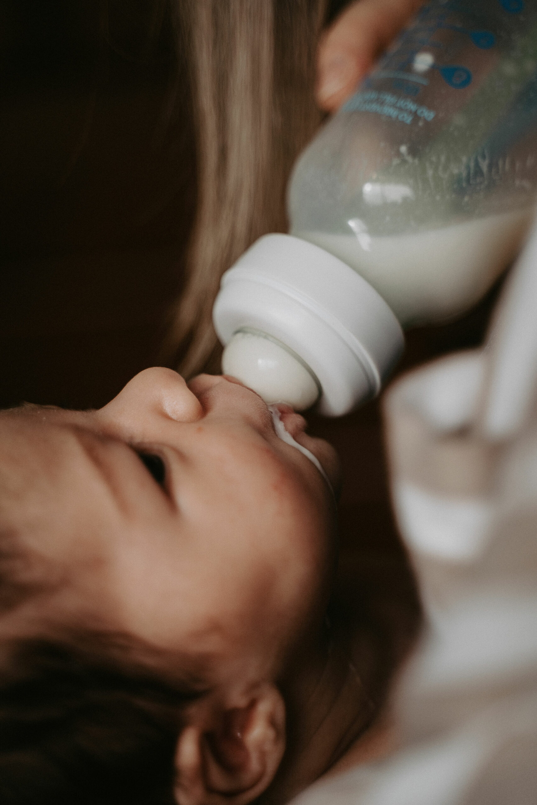 Baby being fed bottle of milk