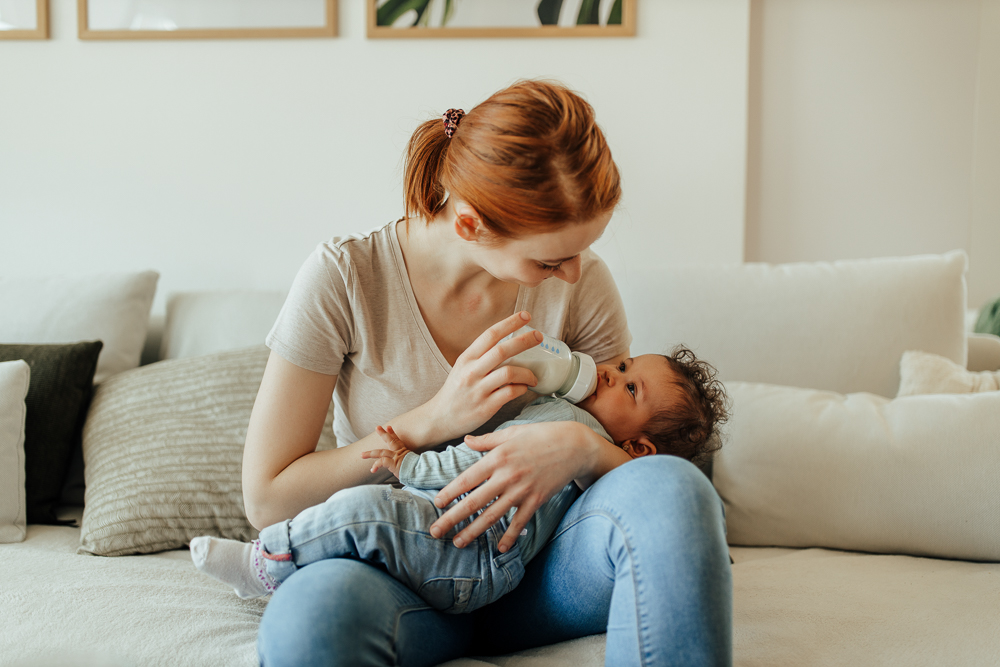 Mum feeding baby bottle of formula