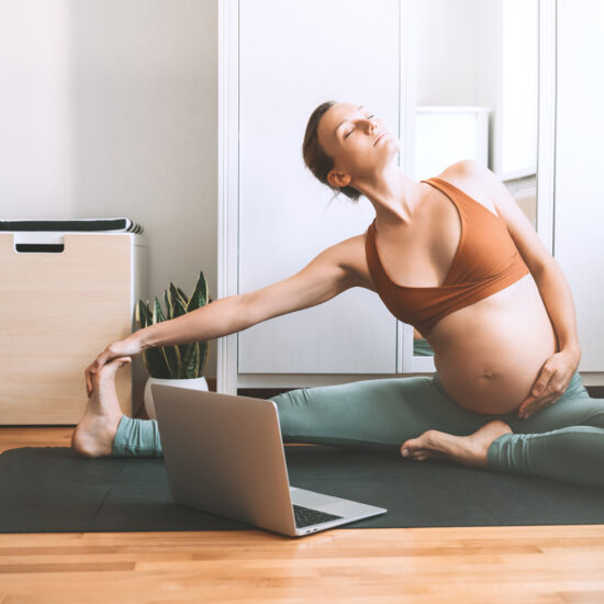 Pregnant mum doing yoga online at home