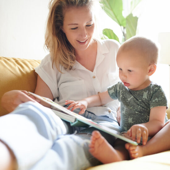Baby reading board book with mum